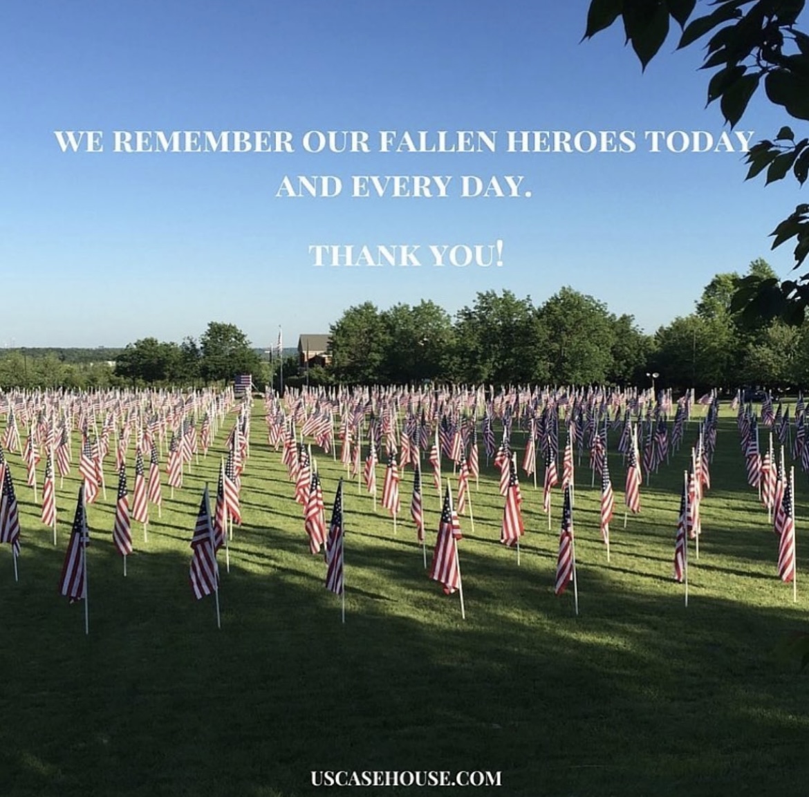 Field of American flags with text in the blue sky reading "We remember our fallen heroes today and every day. Thank you!"